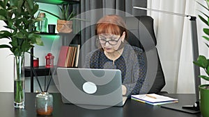 Multitasking at the workplace in the office. Businesswoman is doing a lot of things sitting in modern office. Woman is working on