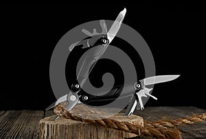 Multitool knife and rope on a dark background photo