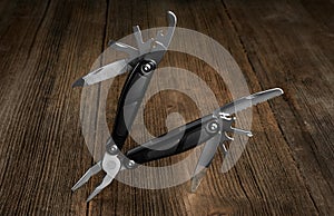 Multitool knife on a wooden background