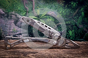 Multitool, multi purpose tool woods background