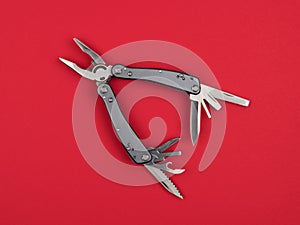 Multitool on a red background closeup