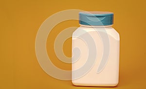 multivitamin bottle on yellow background. copy space. food supplement.