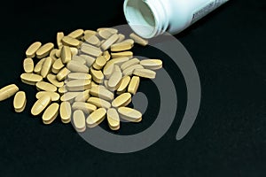 Multivitamin tablets sprinkled and a pills bottle . Selective focus