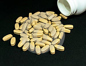 Multivitamin tablets sprinkled and a pills bottle . Selective focus