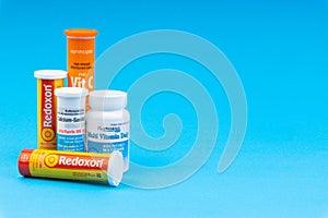 Multivitamin tablets and Vitamin C container closeup.