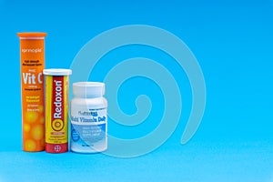 Multivitamin tablets and Vitamin C container closeup.