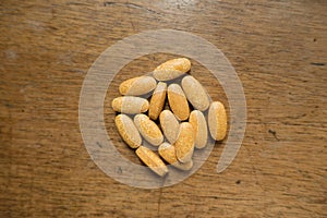 Multivitamin tablets on wooden table