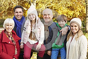 Multl Generation Family By Wooden Fence On Autumn Walk