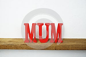 MUM alphabet letter on wooden background