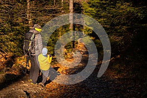 Mum and child are walking along the mountain hiking trail. Family spending time