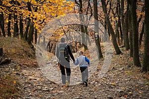 Mum and child are walking along the mountain hiking trail. Family spending time