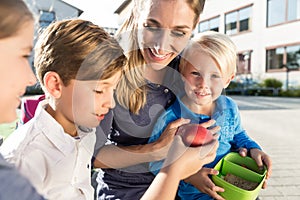 Mum and children having veggie lunch with stripes of bell pepper