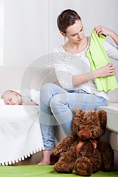 Mum cleaning room and sleeping baby