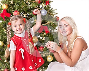 Mum with a daughter decorate christmas tree.