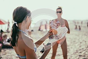 Mum and daughter playing beach tennis or padel tennis at the beach