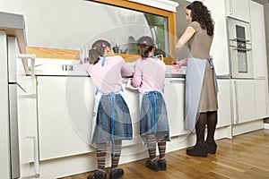 Mum and Daughters Washing Up In Kitchen