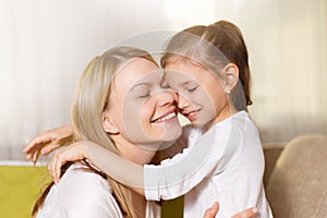 Mum and her cute daughter child girl are playing, smiling and hugging.