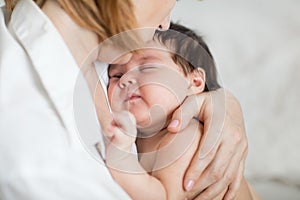 Mum holding her little child daughter. Baby falls asleep in the mother`s arms