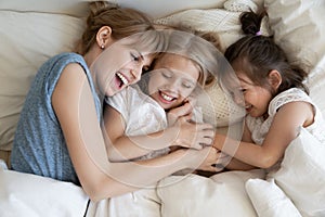 Mum and kids cuddling in bed