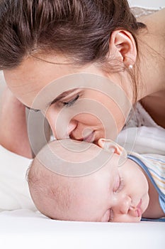 Mum kissing her newborn baby