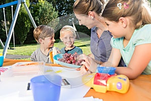 Mum painting pictures with their children during lunch break