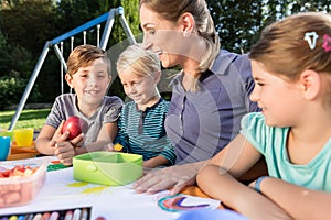 Mum painting pictures with their children and during lunch break