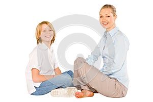 mum and son sat on the floor smiling isolated on white background