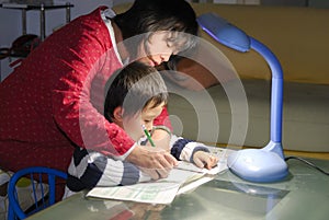 Mum teaching child writting