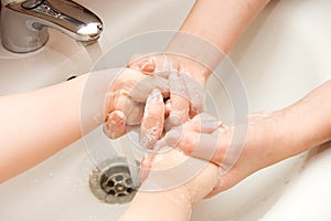 Mum washes hands to the child photo