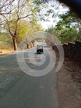 Mumbai a forest road and a riksha.