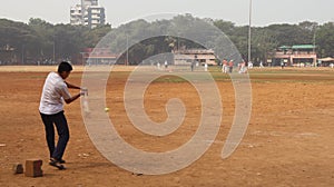 A batsman playing game of cricket. Children enjoying various sports on the playground.