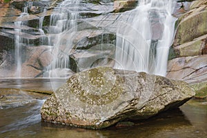 Mumlava waterfall, in the foreground granite stone. Mountain river Mumlava, Krkonose national park, Czech Republic