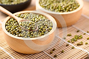 Mung bean seeds in a wooden spoon and bowl, Food ingredients