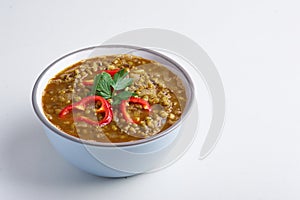 Mung Dhal with red pepper slices isolated at white. Moong Dal - Indian Cuisine curry