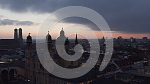 Munich at Night Time with view of Theatinerkirche Cathedral and City lights at Dusk after Sunset, Aerial Dolly slide