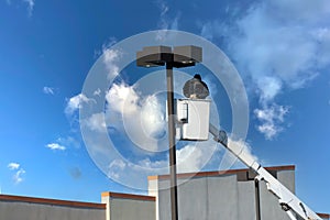 A municipal worker in protective gear replacing bulbs in a street lamp a worker repairing a street lamp