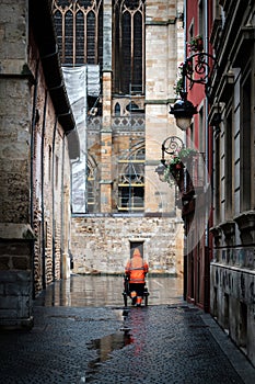 municipal worker with raincoat collecting garbage with his cart, city Leon spain