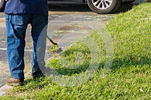 Municipal worker using mower mowing the grass in roadside
