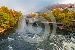 Mur river in autumn, with Murinsel bridge and old buildings in the city center of Graz, Styria region, Austria