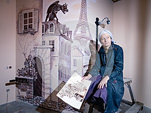 Female artist on the background of unfinished mural. photo
