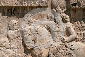 Murals of Necropolis, king burial site of ancient Persia. King on his horse carved into sandstone rock wall.