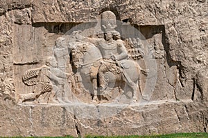 Murals of Necropolis, king burial site of ancient Persia. King on his horse carved into sandstone rock wall.