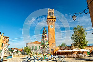 Murano clock tower Torre dell`Orologio of San Stefano church, Colorful christmas tree made of Murano Glass photo