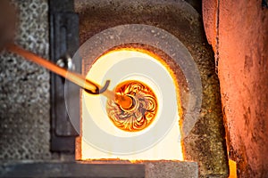 Murano glass-blowing factory. Glass blower forming beautiful pie photo