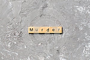 Murder word written on wood block. murder text on table, concept