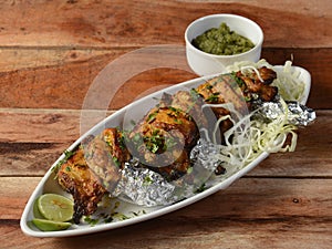 Murgh kalmi kebab on wooden background. Dishes and appetizers of indian cuisine, selective focus