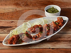 Murgh kebab served on a rustic wooden background. Dishes and appetizers of indian cuisine, selective focus