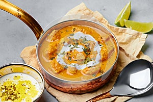 Murgh Makhani or Butter Chicken in copper bowl on gray concrete table top. Indian Cuisine dish
