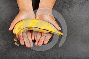 Musa x paradisiaca - Hands holding a ripe banana