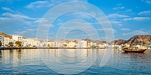 Muscat Skyline with a traditional arabic Dhow